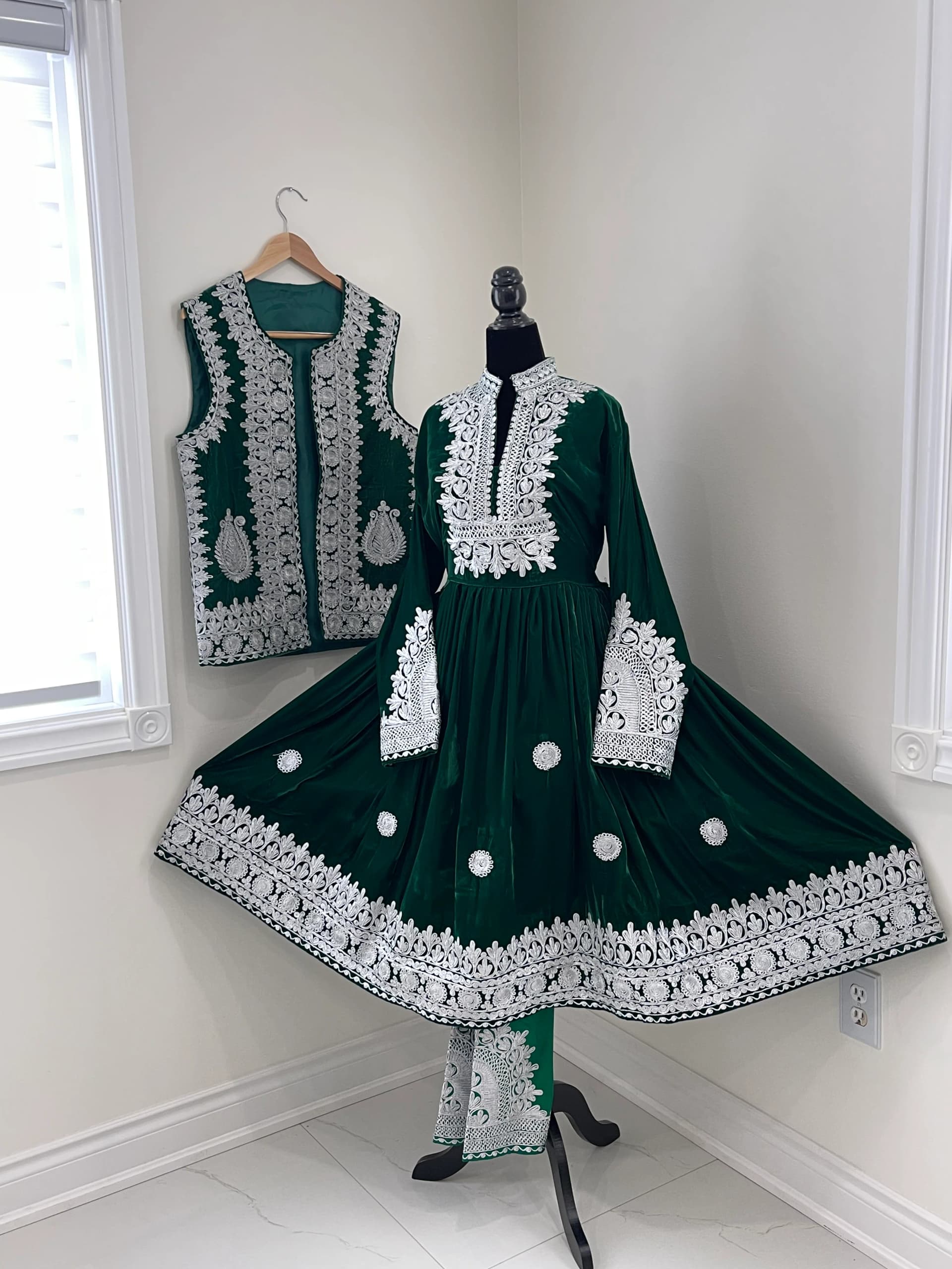 Model in a jade chapan coat layered over an embroidered Afghan dress.